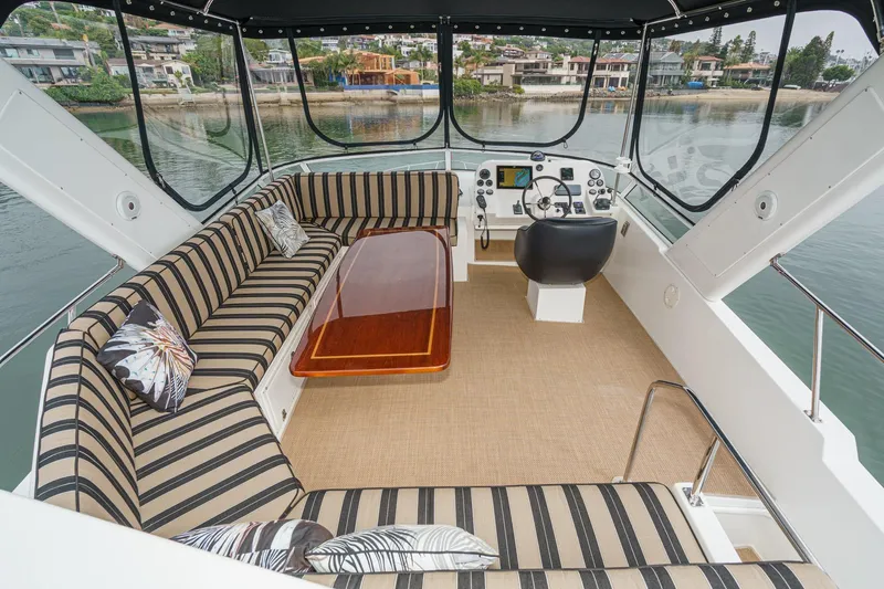 Carrin G Yacht Photos Pics Luxurious 2008 Navigator 4600 Pilothouse interior with striped seating and scenic waterfront view.