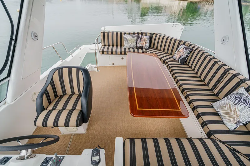 Carrin G Yacht Photos Pics Luxurious seating area on 2008 Navigator 4600 Pilothouse yacht with striped upholstery and elegant table.