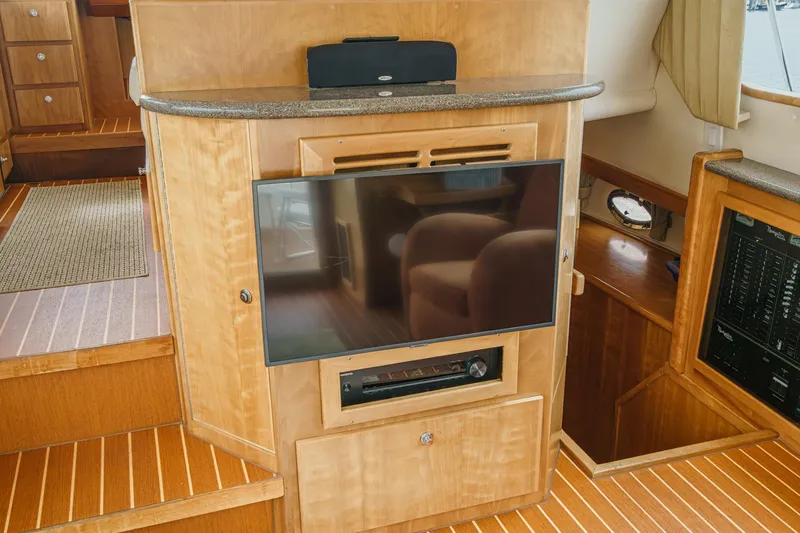 Carrin G Yacht Photos Pics 2008 Navigator 4600 Pilothouse interior with TV and wooden cabinetry.