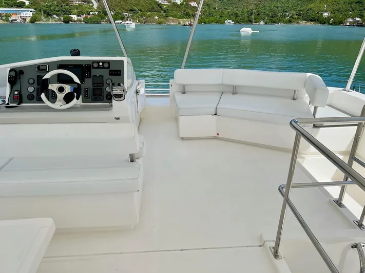 Jamsam Yacht Photos Pics Flybridge of 2017 Leopard 51 Powercat with helm and seating, overlooking serene waters.