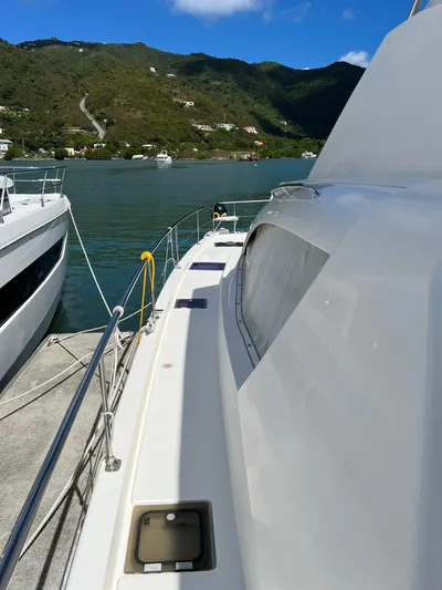 Jamsam Yacht Photos Pics 2017 Leopard 51 Powercat docked in scenic marina with lush hills in background.
