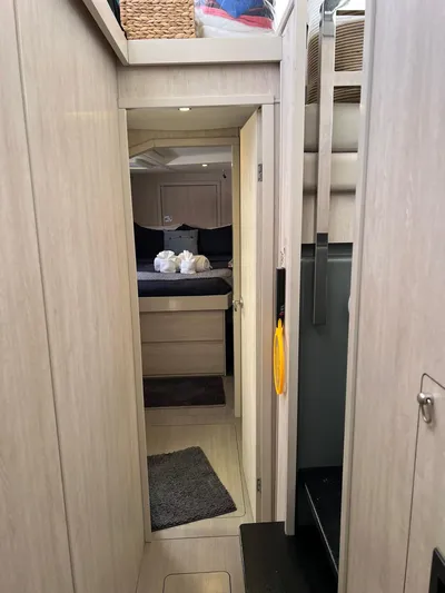 Jamsam Yacht Photos Pics Interior hallway of a 2017 Leopard 51 Powercat yacht, featuring modern design and cozy bedroom.