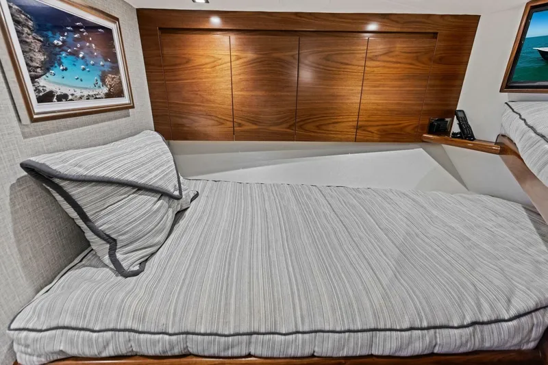 Olde Floridian Yacht Photos Pics 2023 Vikiing convertible yacht interior with cozy bed and elegant wood paneling.