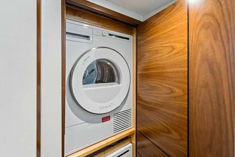 Olde Floridian Yacht Photos Pics 2023 Vikiing convertible laundry area with modern dryer in wooden cabinet.