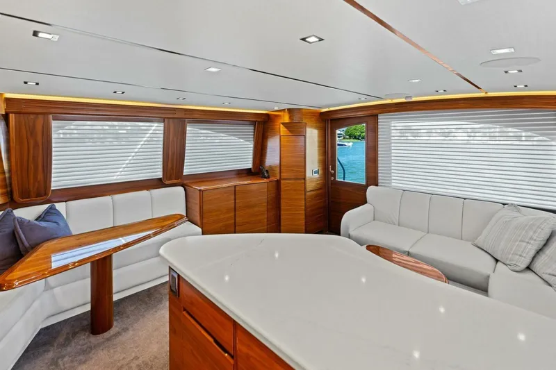 Olde Floridian Yacht Photos Pics Luxurious interior of 2023 Vikiing convertible yacht with elegant wood and white seating.