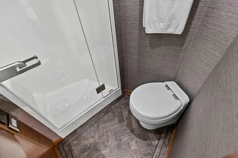 Olde Floridian Yacht Photos Pics Modern bathroom in 2023 Vikiing convertible, featuring sleek toilet and glass shower.