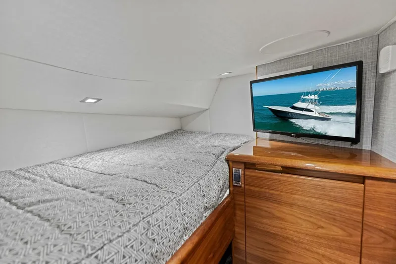 Olde Floridian Yacht Photos Pics 2023 Vikiing convertible yacht interior with bed and TV displaying a boat scene.