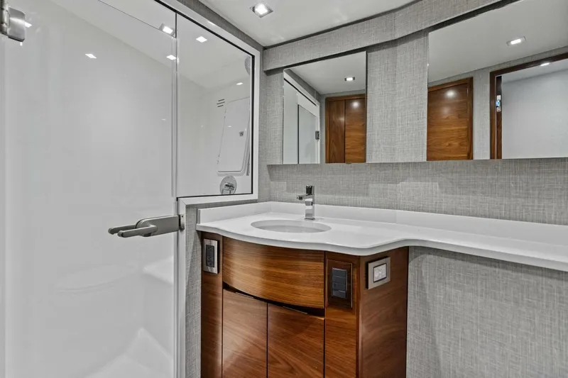 Olde Floridian Yacht Photos Pics Modern bathroom in 2023 Vikiing convertible yacht with sleek design and wooden cabinetry.
