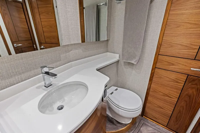 Olde Floridian Yacht Photos Pics Modern bathroom in 2023 Vikiing convertible, featuring sleek sink and wooden cabinetry.