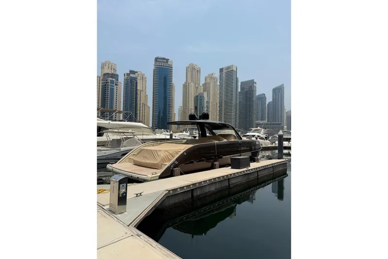  Yacht Photos Pics 2024 Invictus TT460 yacht docked in marina with city skyline backdrop.