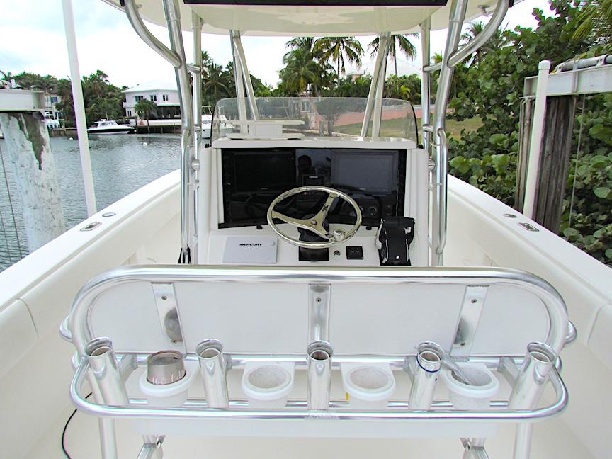 2005 Venture 34 Open boat helm with steering wheel and rod holders, docked by a canal.