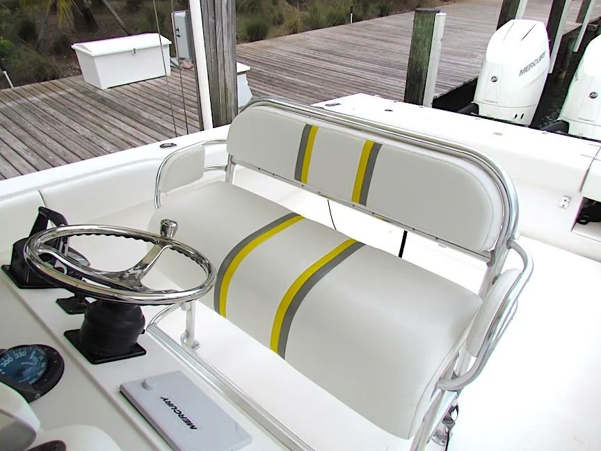 2005 Venture 34 Open boat helm with striped seating and steering wheel.