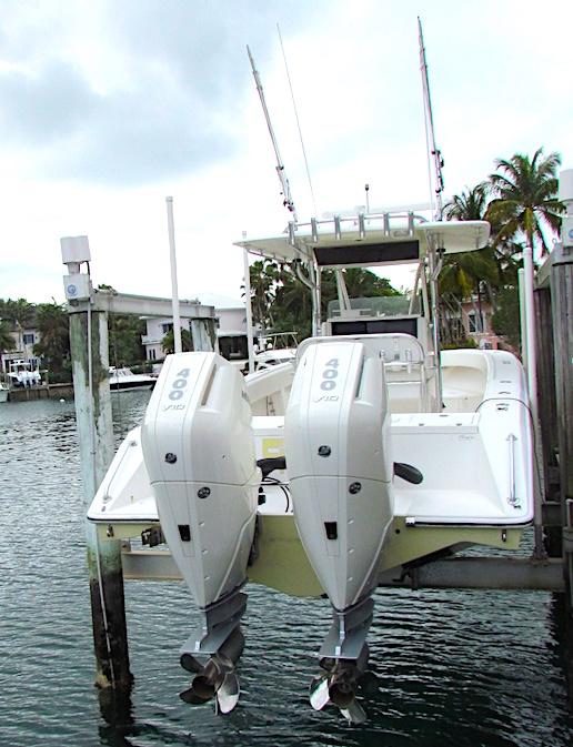 2005 Venture 34 Open boat with dual outboard engines docked by the water.