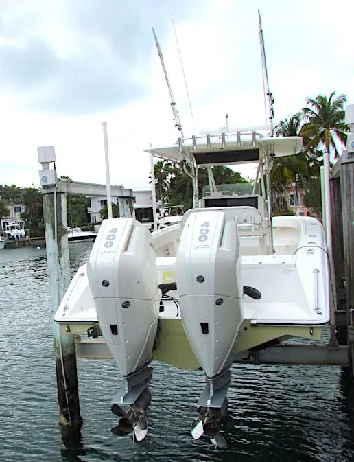 2005 Venture 34 Open boat with dual outboard engines docked by the water.