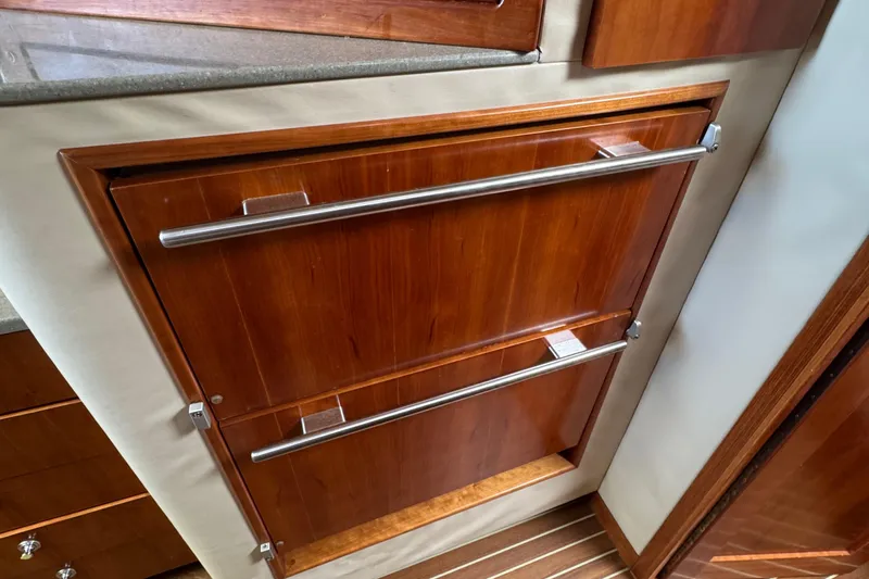 Stewartship Yacht Photos Pics Wooden cabinetry with metal handles in a 2007 Albemarle 410 Express Fisherman boat interior.