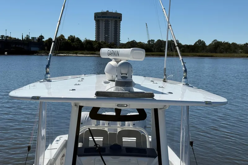  Yacht Photos Pics 2022 Regulator 34 boat with Garmin radar on calm water, distant building in background.