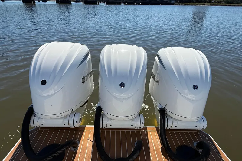  Yacht Photos Pics Triple Yamaha outboard engines on 2022 Regulator 34 boat, docked on calm water.