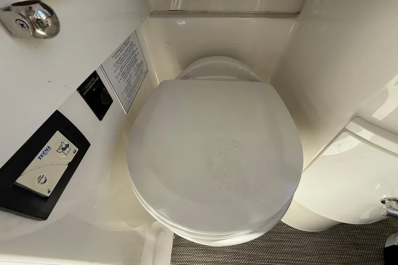  Yacht Photos Pics 2022 Regulator 34 boat bathroom with Tecma marine toilet and control panel.