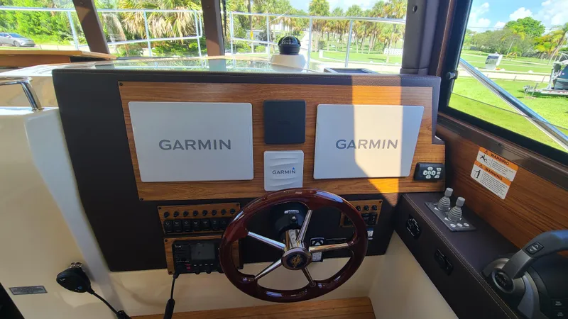 Gadabout Yacht Photos Pics 2024 Ranger Tugs R-29 CB helm with Garmin navigation displays and wooden steering wheel.