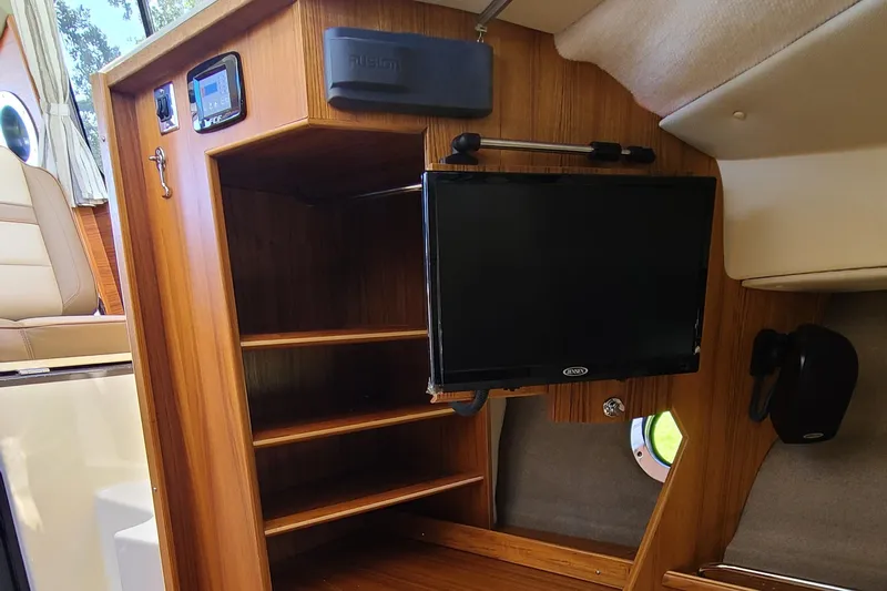 Gadabout Yacht Photos Pics 2024 Ranger Tugs R-29 CB interior with wooden shelves and mounted TV.