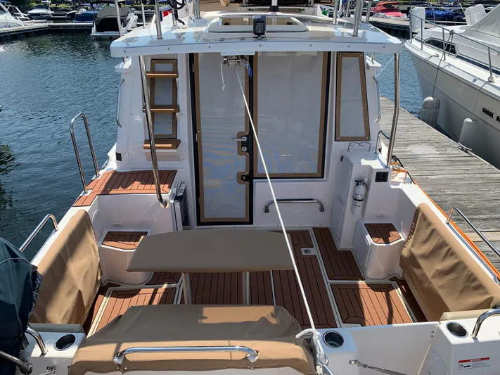 Gadabout Yacht Photos Pics 2024 Ranger Tugs R-29 CB boat deck with seating and wood accents at a marina.