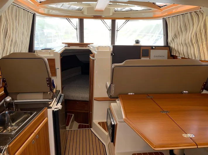 Gadabout Yacht Photos Pics 2024 Ranger Tugs R-29 CB interior with wood finishes, seating, and navigation equipment.