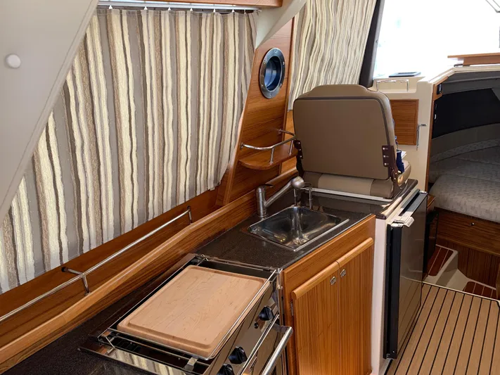Gadabout Yacht Photos Pics 2024 Ranger Tugs R-29 CB interior with kitchenette, sink, and seating area.