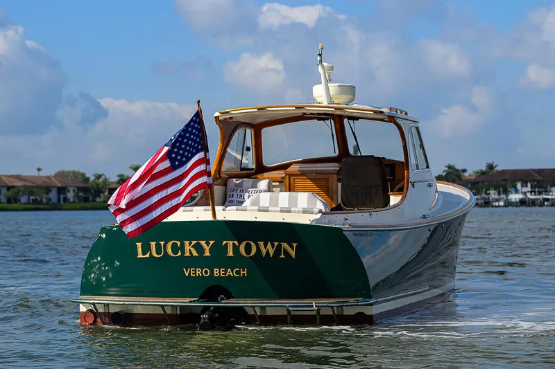 Lucky Town Yacht Photos Pics 2000 Hinckley Picnic Boat Classic on water, American flag, "Lucky Town" text, Vero Beach.