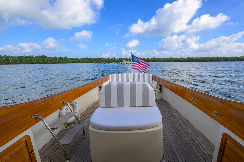 Lucky Town Yacht Photos Pics Hinckley Picnic Boat Classic 2000 on water, featuring striped seating and American flag.