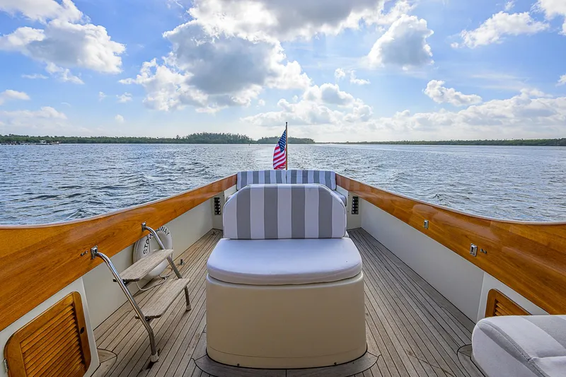 Lucky Town Yacht Photos Pics 2000 Hinckley Picnic Boat Classic on serene water, featuring elegant wooden deck and striped seating.
