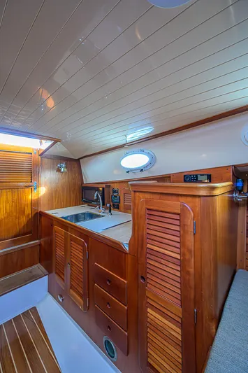 Lucky Town Yacht Photos Pics Interior of 2000 Hinckley Picnic Boat Classic with wooden cabinetry and compact kitchen area.