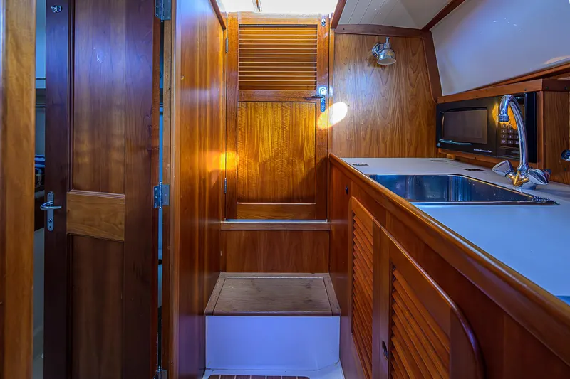 Lucky Town Yacht Photos Pics Interior of 2000 Hinckley Picnic Boat Classic with wooden cabinetry and stainless steel sink.