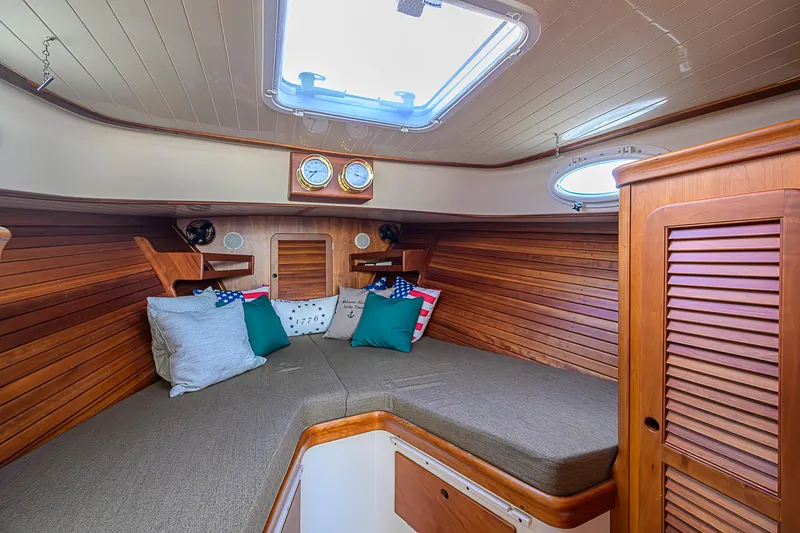 Lucky Town Yacht Photos Pics Cozy cabin interior of 2000 Hinckley Picnic Boat Classic with wood paneling and cushions.