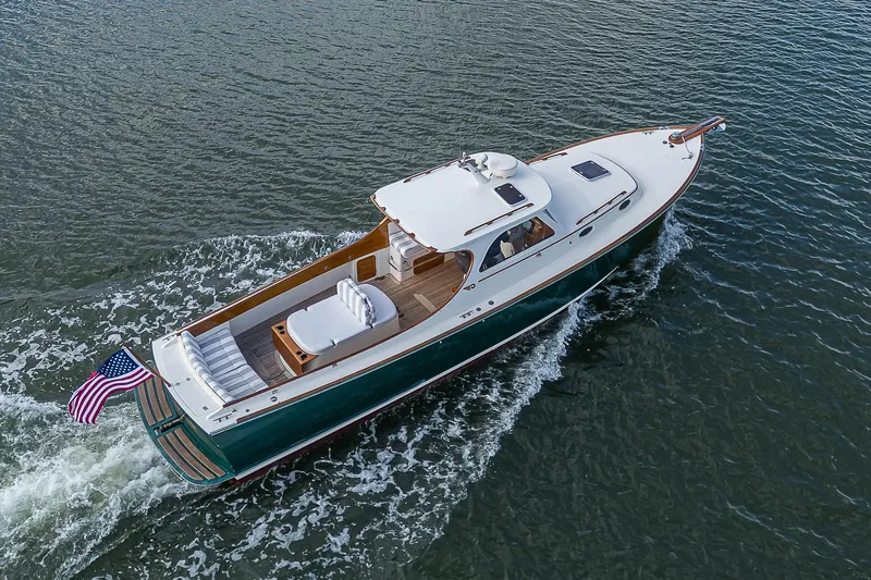 Lucky Town Yacht Photos Pics Hinckley Picnic Boat Classic 2000 cruising on water, featuring elegant design and American flag.