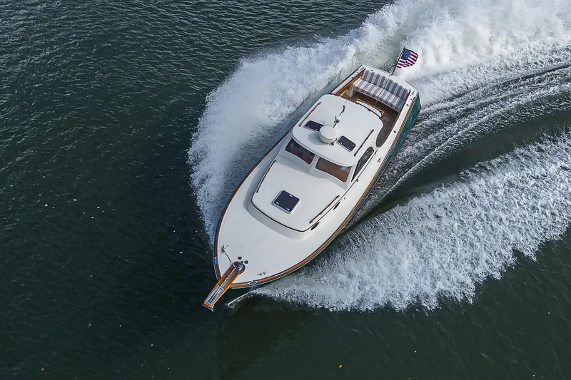 Lucky Town Yacht Photos Pics Hinckley Picnic Boat Classic 2000 cruising on water, aerial view, American flag visible.