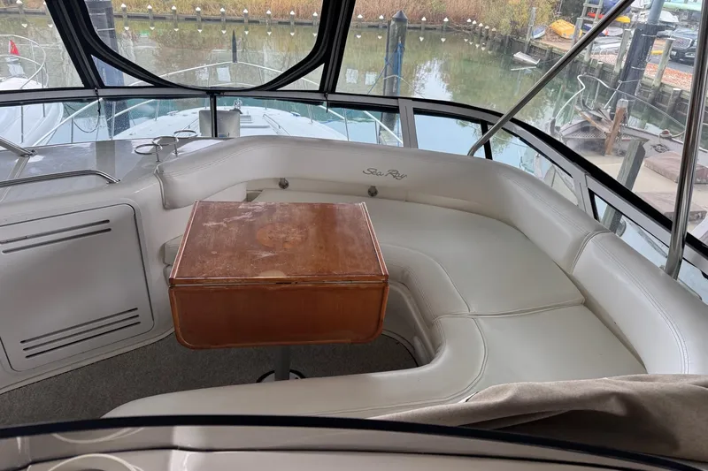  Yacht Photos Pics Luxurious 2003 Sea Ray 480 Sedan Bridge interior with white seating and wooden table.