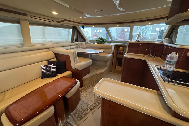  Yacht Photos Pics Luxurious interior of 2003 Sea Ray 480 Sedan Bridge yacht with elegant seating and kitchen area.