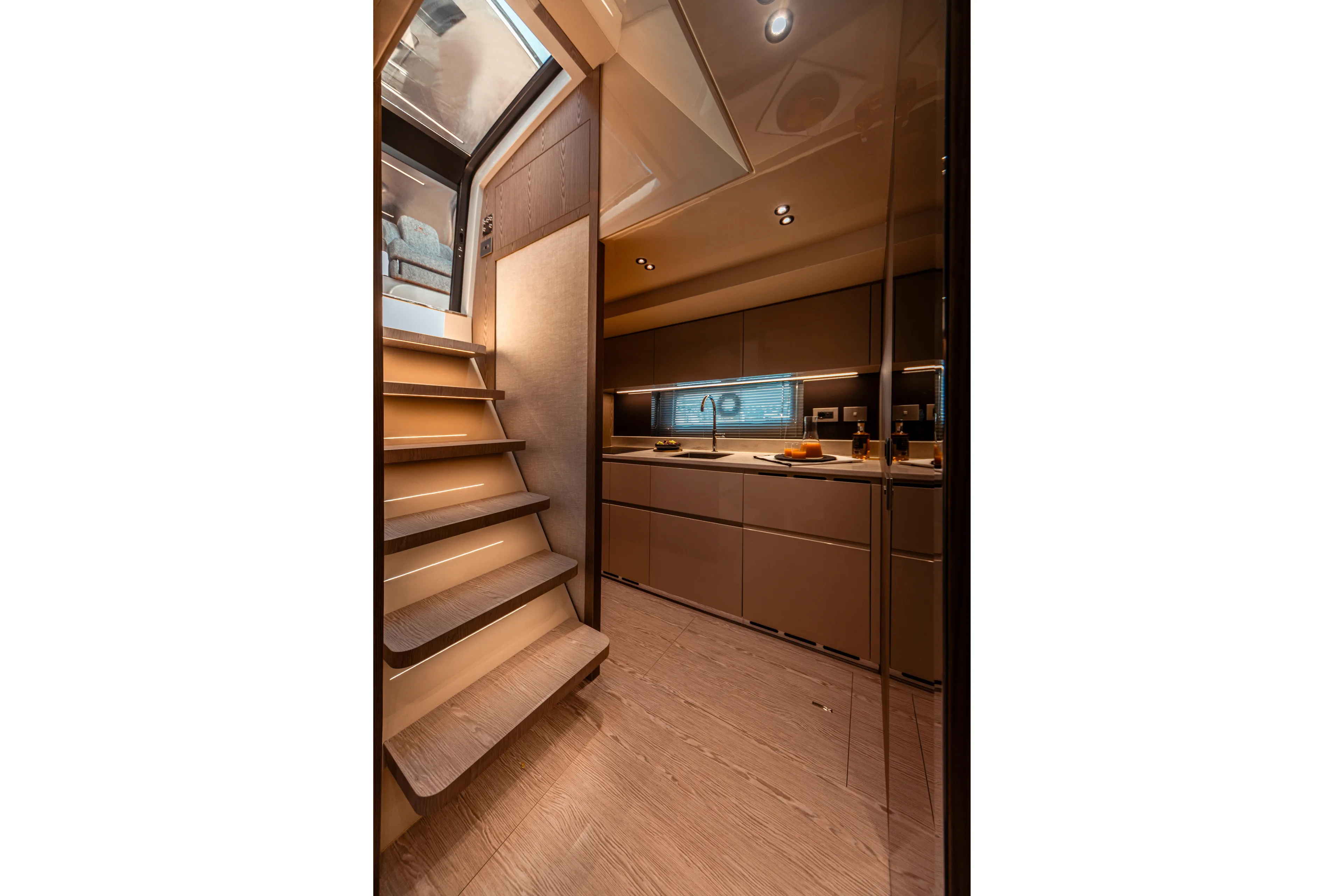  Yacht Photos Pics Luxurious interior of 2025 Invictus TT550 yacht with modern kitchen and wooden stairs.