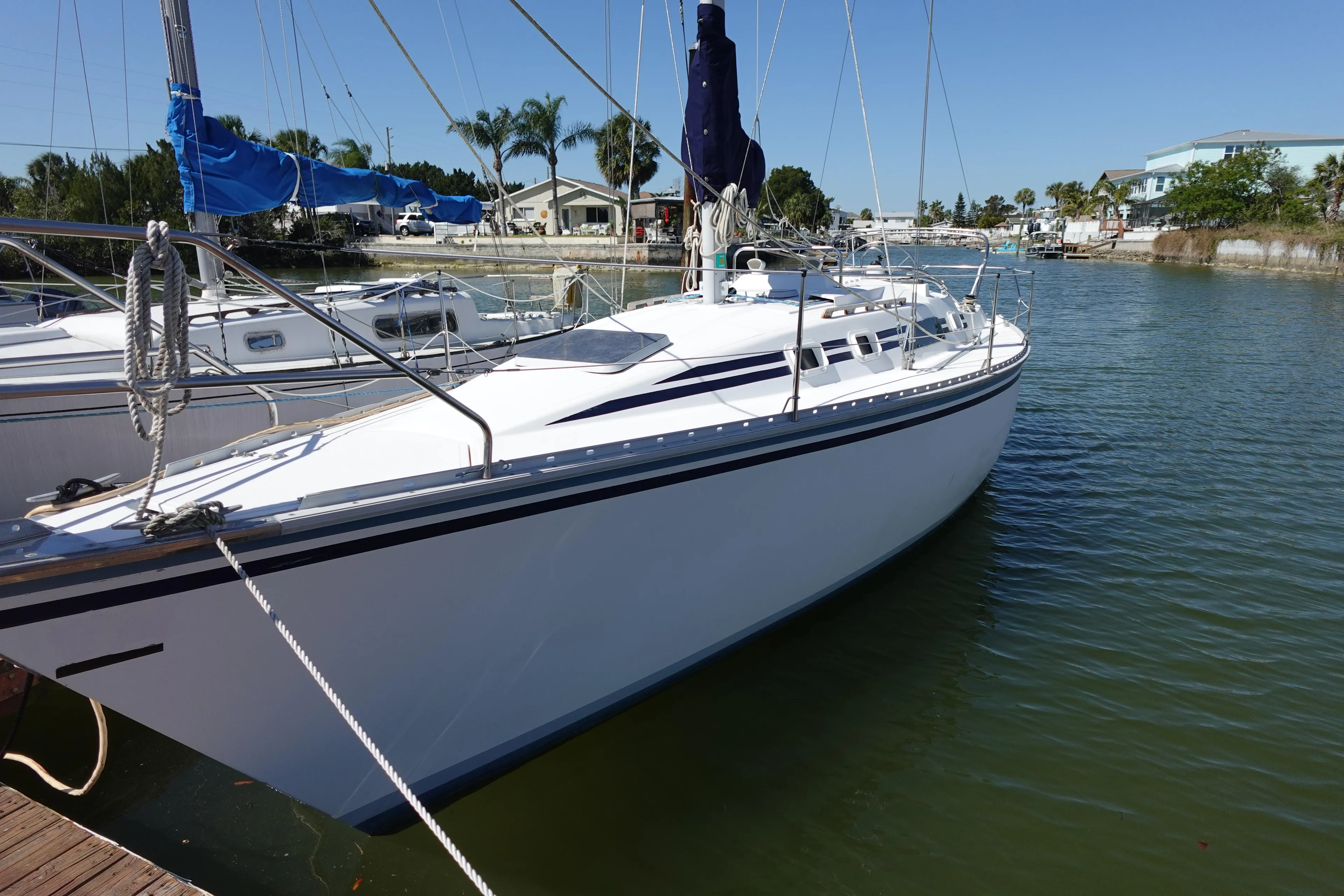 1987 Hunter 310 sailboat docked in a marina, clear sky, calm water.