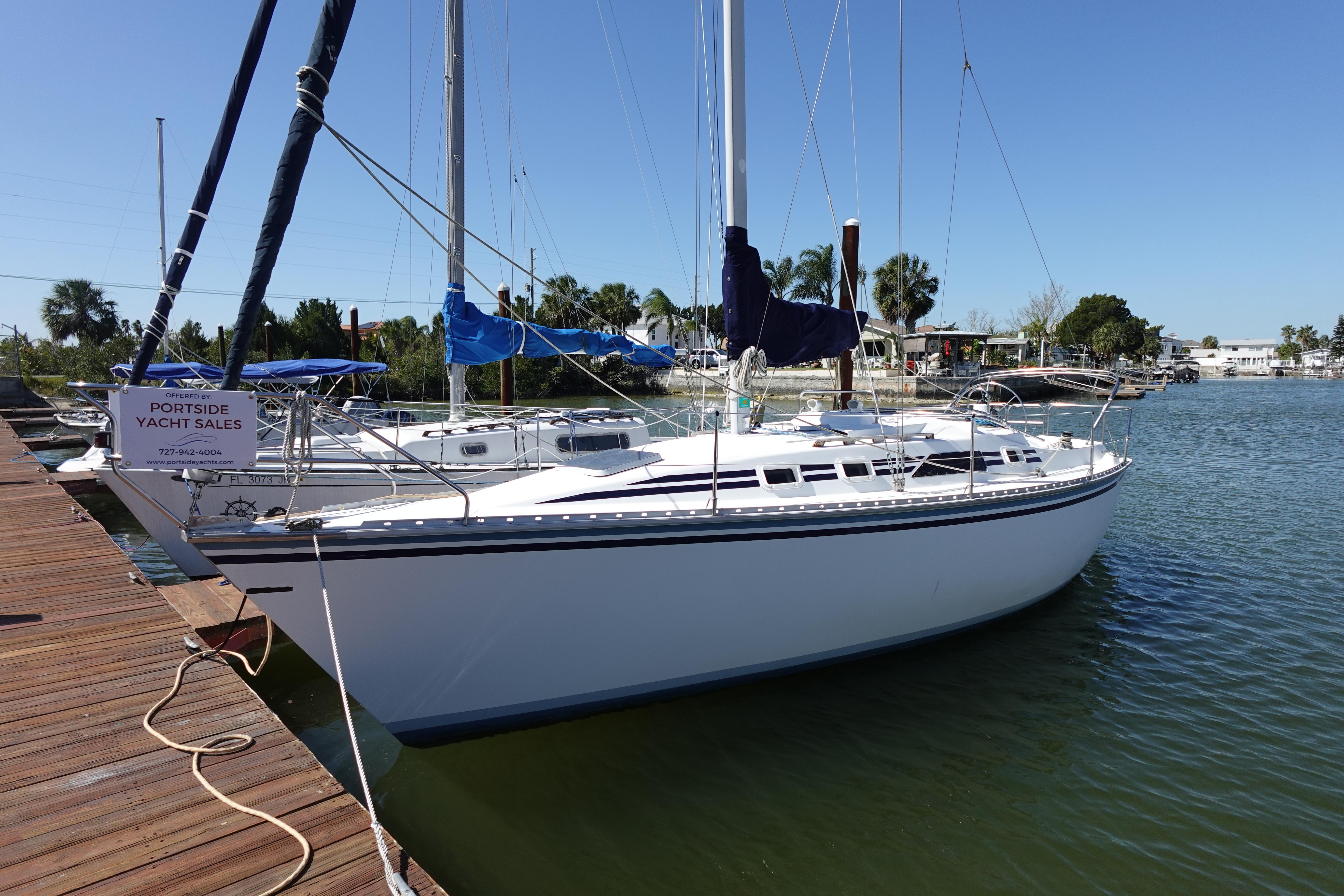 1987 Hunter 310 sailboat docked at marina under clear blue sky.