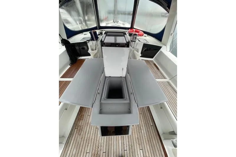 V-1 Yacht Photos Pics 2018 Beneteau Oceanis 45 yacht cockpit with foldable table and sink, featuring teak flooring.