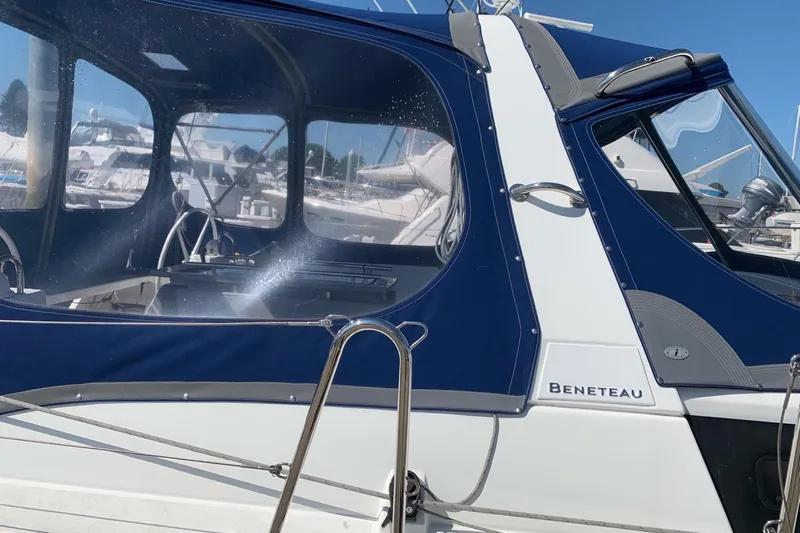 V-1 Yacht Photos Pics 2018 Beneteau Oceanis 45 sailboat with blue canopy, docked in marina.