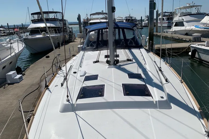 V-1 Yacht Photos Pics 2018 Beneteau Oceanis 45 sailboat docked at marina, surrounded by other boats.
