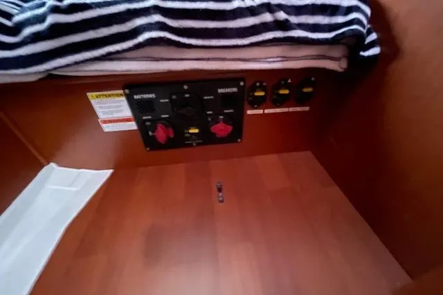V-1 Yacht Photos Pics Electrical panel inside 2018 Beneteau Oceanis 45 yacht cabin with striped blanket above.