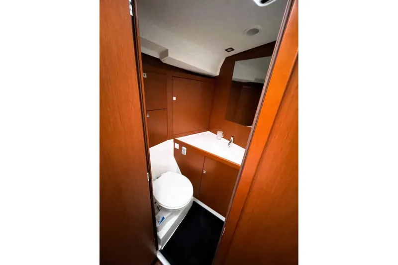 V-1 Yacht Photos Pics Interior of 2018 Beneteau Oceanis 45 yacht bathroom with wooden cabinetry and modern fixtures.