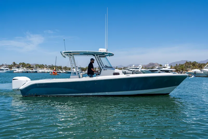 Carnal Yacht Photos Pics 2020 Edgewater 320CC boat cruising on a sunny day in a marina.