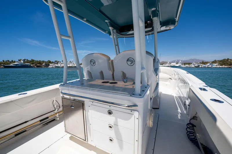Carnal Yacht Photos Pics 2020 Edgewater 320CC boat interior with seating and storage, docked on a sunny day.