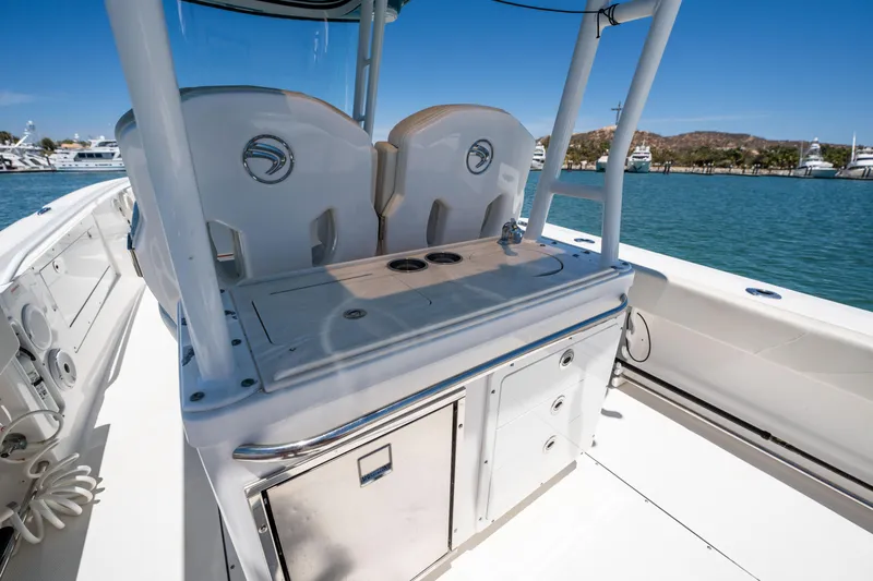 Carnal Yacht Photos Pics Edgewater 320CC boat interior, featuring helm seating and storage, docked by a marina.
