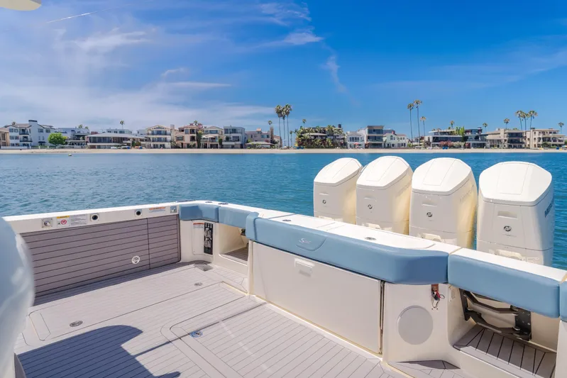 Mandalorian Yacht Photos Pics 2023 Scout 530 LXF boat with four engines, docked near waterfront homes.