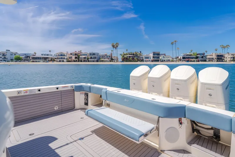 Mandalorian Yacht Photos Pics 2023 Scout 530 LXF boat with four engines, docked near waterfront homes.